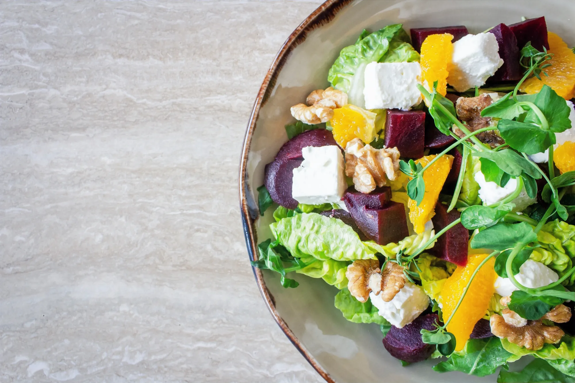 A fresh salad bowl with beetroot, feta, orange and walnuts